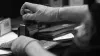 Closeup of the latex-gloved hands of an immigration officer stamping a passport
